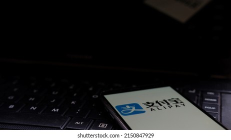 Jakarta, Indonesia - April 29, 2022: AliPay logo display on smartphone with keyboard background