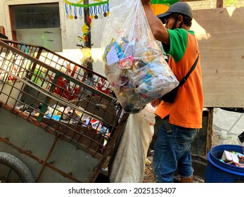 Jakarta, Indonesia - August 15, 2021: A Man Is Collecting Plastic Garbage And Put It Into Traditional Truck Named As  Gerobak Sampah In Afternoon Time , Jakarta On August 2021