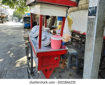 Jakarta, Indonesia, August 2, 2021 a seller of green bean porridge and black sticky rice, tukang bubur kacang ijo dan ketan item, is peddling his food on the side of the road from his cart or gerobak.