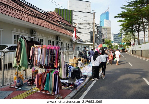 Jakarta, Indonesia -\
August, 2022 : The situation of many clothing street vendor.\
Clothing shoppers haggle with street vendors on Sunday mornings at\
a car free day event.