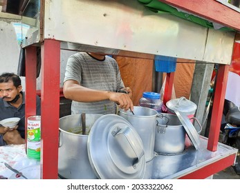 Jakarta, Indonesia, August 28, 2021, a green bean and black sticky rice porridge vendor or tukang bubur kacang ijo dan ketan item prepares his food, from his food street cart or gerobak pinggir jalan