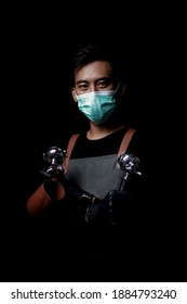 JAKARTA, INDONESIA - DECEMBER 2020: Service Minded Handsome Smiling Asian Barista Serving Coffee Studio Shot Isolated On Black Background