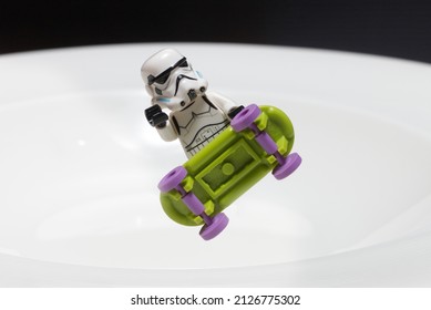 Jakarta, Indonesia - Feb 21, 2022 : A lego stormtrooper play skateboard on white bowl in black background