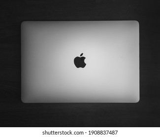 JAKARTA, INDONESIA – FEBRUARY 02, 2021: Macbook On A Black Background With Wood Texture.