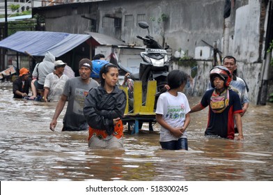 Jakarta, Indonesia - February 10, 2015 : Jakarta resident walk across the flooding street in Grogol, Jakarta, Indonesia. Heavy rains caused some flooded areas in Jakarta.
