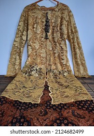 Jakarta, Indonesia. February 17, 2022. Traditional dress typical of Central Java, Indonesia: long yellow kebaya (blouse) combined with hand written traditional batik in brown and beautiful brooches.