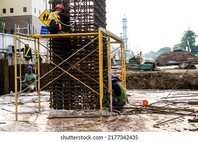 Jakarta, Indonesia - February 21st 2020: Construction Workers Are Installing Pier Rebar For Reinforcement In Site Construction Project. He Is Standing On Scafolding.