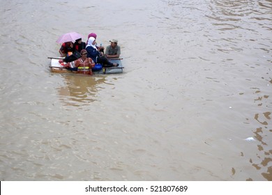 Jakarta, Indonesia - January 18, 2014: Jakarta Residents Across Flood Using Homemade Rafts