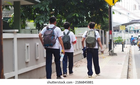 JAKARTA - INDONESIA - JUL 26, 2022: Three Boys Go Back To School, Each Wearing A Backpack And A White Shirt