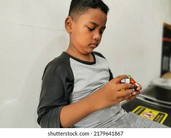 Jakarta, Indonesia - July 18, 2022: Kid Playing Rubik's Cube. Rubik's Cube Invented By A Hungarian Architect Erno Rubik In 1974.