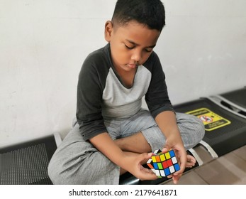 Jakarta, Indonesia - July 18, 2022: Kid Playing Rubik's Cube. Rubik's Cube Invented By A Hungarian Architect Erno Rubik In 1974.