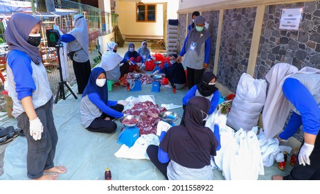 JAKARTA, INDONESIA - JULY 20, 2021: Several People Wearing Mask Are Weighing And Packing Meat During Eid Al-Adha With Strict Covid 19 Health Protocol.