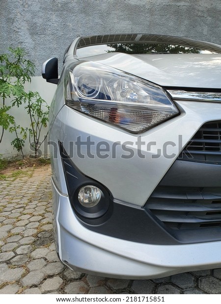 Jakarta,\
Indonesia - July 23, 2022: Front side photo of a car with detailed\
headlights and fog lamps and front\
bumper