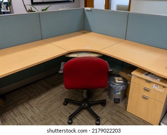 Jakarta, Indonesia - July 3, 2022: An Empty Cubicle Desk With Light Blue Partition, A Scarlet Chair, A Grey Trash Can, And A Drawer Cabinet.