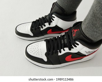 Jakarta, Indonesia - June 11th 2021: Woman Wearing A Nike Air Jordan 1 Shoes Isolated In Broken White Background 