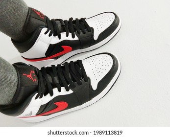 Jakarta, Indonesia - June 11th 2021: Woman Wearing A Nike Air Jordan 1 Shoes Isolated In Broken White Background 