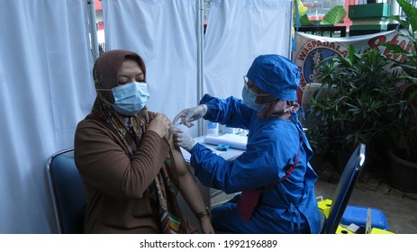 Jakarta, Indonesia - June 15 2021 : Asian Woman Given The Covid-19 Vaccine Shot On Left Upperarm Or Vaksin Covid