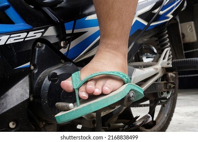 Jakarta, Indonesia - June 17, 2022 : selected focus, narrow depth of field Motorcyclists have no protection for their feet when riding using flip-flops.