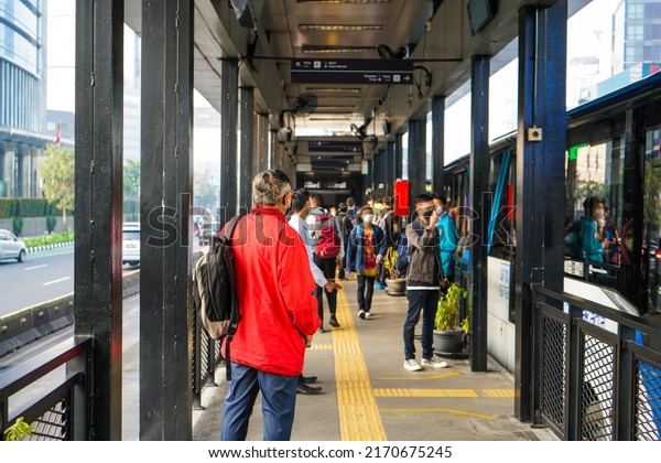 Jakarta, Indonesia - June, 2022 : \
The\
situation in the bus stop or Transjakarta bus terminal which is\
very crowded with workers going to the\
office.