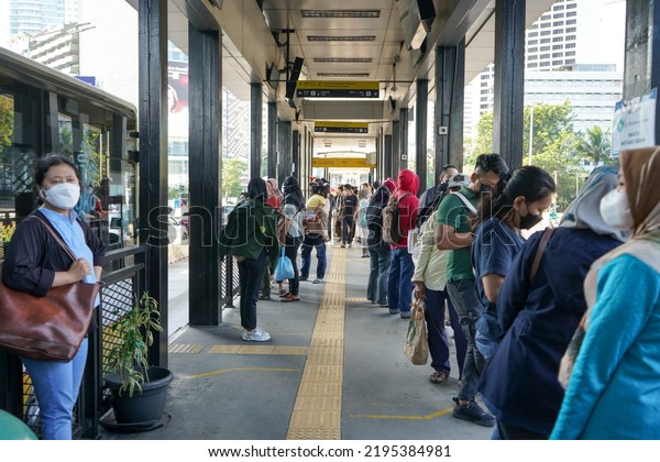 Jakarta, Indonesia - June, 2022 : \
The\
situation in the bus stop or Transjakarta bus terminal which is\
very crowded with workers going to the office. Passengers using\
mask waiting for Trans\
Jakarta.