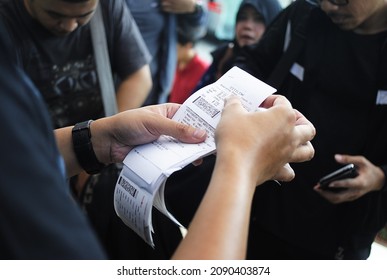 Jakarta, Indonesia - June 22nd 2014, Tour Leader Distributing Check-in Tickets At The Airport, Jakarta, Indonesia.