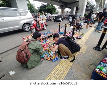 Jakarta, Indonesia – June 4,2022 : Two Young Men Are Choosing Toys At A Secondhand Seller, South Jakarta, Indonesia On June 4,2022