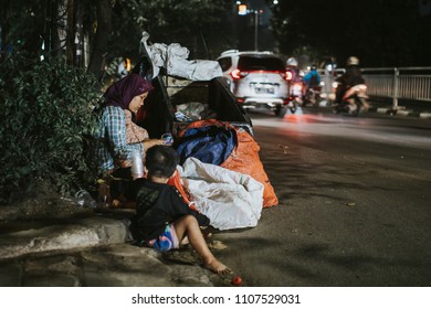 JAKARTA, INDONESIA - MARCH 15, 2018: Woman With Children Collecting Plastic Waste From The Streets In Jakarta, Indonesia.