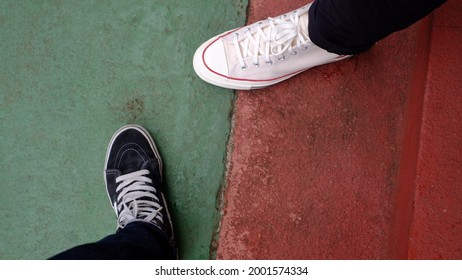 Jakarta, Indonesia - March 30, 2021: Two Men Wearing Converse Shoes And Vans On The Street, During The Day