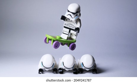 Jakarta, Indonesia - May 13, 2014 : A lego stormtrooper jump with his skateboard over his three fellows in white background