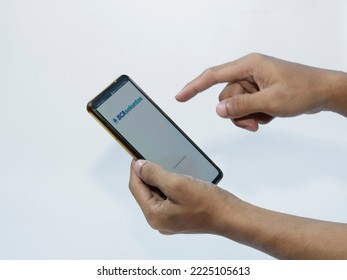 Jakarta, Indonesia - November 08, 2022: A Man Uses The BCA Securities Application On His Smartphone, A Popular Stock Trading Company In Indonesia To Buy Stocks Easily Without Coming To The Stock Excha