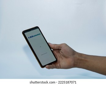 Jakarta, Indonesia - November 08, 2022: A Man Uses The BCA Securities Application On His Smartphone, A Popular Stock Trading Company In Indonesia To Buy Stocks Easily Without Coming To The Stock Excha