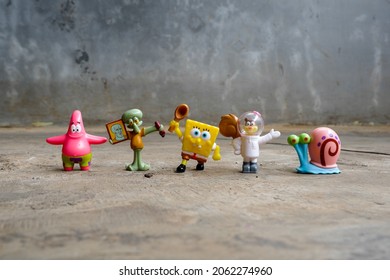 Jakarta, Indonesia - October 21, 2021: Spongebob, Patrick, Squidward, Sandy, and Gary figure with wall background. Cartoon character plastic toy adapted from a cartoon movie "Spongebob Squarepants".