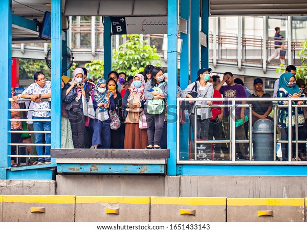 Jakarta, Indonesia : Passengers using\
mask in Gelora Bung Karno shelter waiting for Trans Jakarta buses,\
mass public transportation in the capital\
(02/2020).