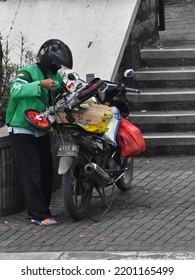 Jakarta, Indonesia - September 13th 2022: A Grab Driver Is Putting Bike On His Motorbike For Delivery