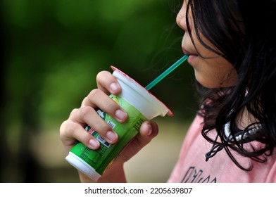 Jakarta, Indonesia - September 23, 2022 : A Little Girl Is Drinking Sweet Tea In A Plastic Cup, Too Often Drinking A Sweet Drink In A Cup Can Trigger Diabetes In Children