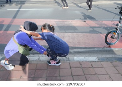 Jakarta, Indonesia - September 4 2022: A Mother Helps Her Son Tie His Shoelaces.