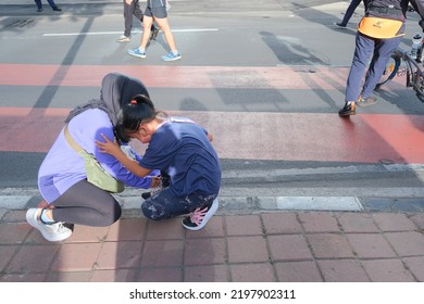 Jakarta, Indonesia - September 4 2022: A Mother Helps Her Son Tie His Shoelaces.