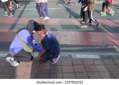 Jakarta, Indonesia - September 4 2022: A Mother Helps Her Son Tie His Shoelaces.