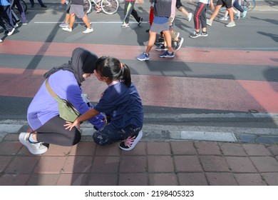 Jakarta, Indonesia - September 4 2022: A Mother Helps Her Son Tie His Shoelaces.