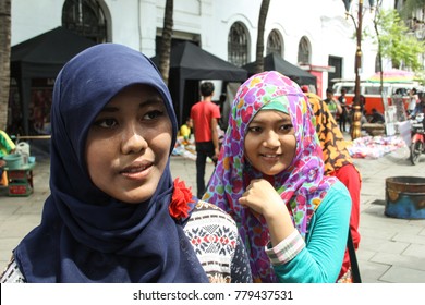 JAKARTA, INDONESIA-APR. 6, 2014: Indonesian Women In Colorful Scarves Practice Their English With Passing Tourists.