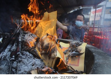 JAKARTA, INDONESIA-FEBRUARY 2022- Chinese devotees burn Joss Papers during Chinese New Year worship at the Vihara on February 01, 2022 in Jakarta.
