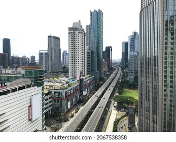 Jakarta, October 19th 2021 - The Hustle And Bustle Of Downtown Jakarta During The Day.  Flyover In The Middle Of Office Buildings And Apartments