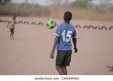 Jali, Gambia, Africa, May 18, 2017: Horizontal Close Up Photography Of Elementary School Boy Students Playing Football With New Balls, Barefood On Sandy Field, Outdoors On A Sunny Day