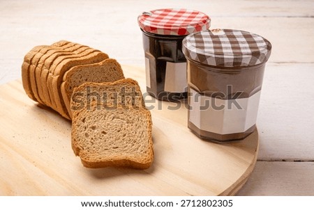 Jam jars, a rustic white table with toast and jam jars, selective focus.