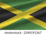 Jamaica flag with big folds waving close up under the studio light indoors. The official symbols and colors in fabric banner