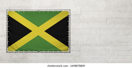 Jamaica-Flagge auf einer Plane auf einer Betonwand