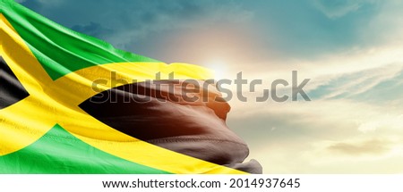 Jamaica national flag waving in beautiful sky.