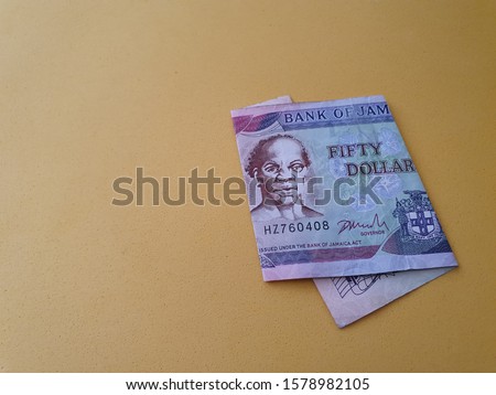 Jamaican banknote of fifty dollars and yellow background for advertising