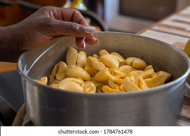 a Jamaican woman's hand  rests on a pan of ackee, one of Jamaica's famous fruits