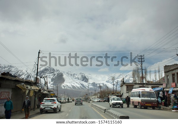 JAMMU KASHMIR, INDIA - MARCH 20 : Traffic road and\
Indian people drive car and riding motorcycle and walking on\
Srinagar Leh Ladakh highway at Leh Ladakh on March 21, 2019 in\
Jammu and Kashmir, India